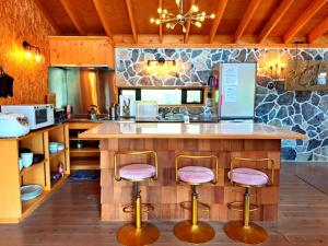 a kitchen with a large counter with stools around it at Cottage Flamingo - Vacation STAY 58478v in Minato