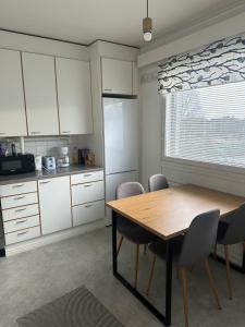 a kitchen with a wooden table and chairs and a window at Hostel400Kokkola Kaksio Hollihaka in Kokkola