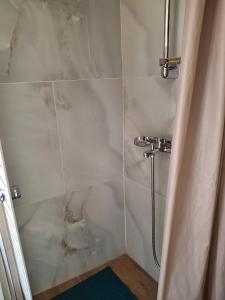 um banheiro com chuveiro e porta de vidro em Nafpaktos happy town studio in port em Lepanto