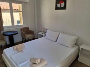 um quarto com uma cama branca com toalhas em Nafpaktos happy town studio in port em Lepanto