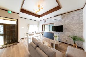 a living room with a couch and a brick wall at Setsuki no Yado - Vacation STAY 20324 in Kamagaya