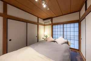 a bedroom with a bed and a large window at Setsuki no Yado - Vacation STAY 20324 in Kamagaya