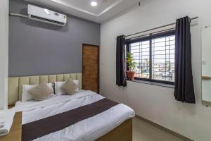 Un dormitorio con una cama y una ventana en Hotel NS Premium, en Nagpur