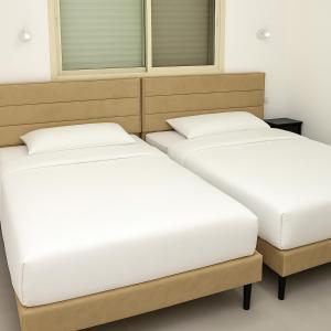twee bedden naast elkaar in een kamer bij לב בית שאן in Bet Sheʼan