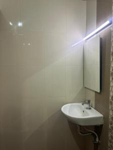 un baño con lavabo y espejo en Krypton beach paradise, en Covelong