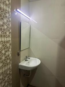 un baño con lavabo y espejo en Krypton beach paradise, en Covelong