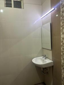 un baño con lavabo y espejo en Krypton beach paradise, en Covelong