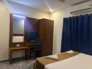 Un dormitorio con una cama, un escritorio y un espejo. en Krypton beach paradise, en Covelong