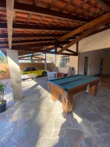 einen Billardtisch auf einer Terrasse mit einem Auto in der Unterkunft Soul Beach Hostel in Bertioga