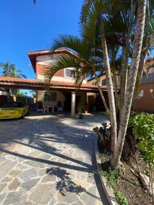 ein gelbes Auto, das vor einem Gebäude mit einer Palme geparkt ist in der Unterkunft Soul Beach Hostel in Bertioga + 14 Fotos