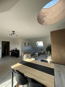 a living room with a table and a couch at Appartement Dôme 2 suites parentales in Ostwald