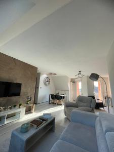 a living room with a couch and a table at Appartement Dôme 2 suites parentales in Ostwald