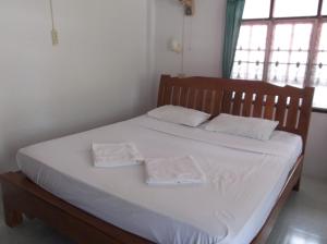 a bed with white sheets and white towels on it at Palm Point Village in Mae Nam