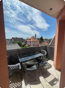 a balcony with a table and chairs on a roof at Appartement Dôme 2 suites parentales in Ostwald