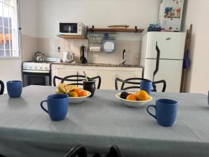 a table with two bowls of oranges and cups on it at Las Grutas Star in Las Grutas