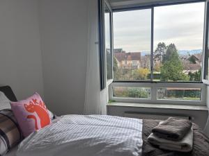 a bedroom with a bed and a large window at Ferienwohnung Karma in Kressbronn am Bodensee