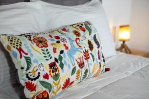 ein Kissen mit Blumenmuster auf einem Bett in der Unterkunft Mikros Paradisos Pelion in Áyios Vlásios + 93 Fotos