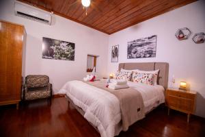 ein Schlafzimmer mit einem großen Bett und einem Stuhl in der Unterkunft Mikros Paradisos Pelion in Áyios Vlásios