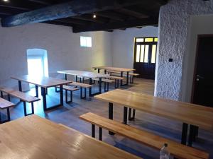 a row of tables and benches in a room at Kuća za proslave Marković in Baranjsko Petrovo Selo