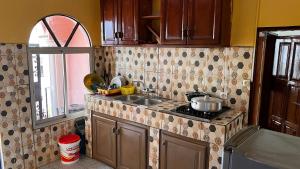 a kitchen with a sink and a stove and a window at BARAN Home in Yaoundé