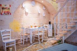 ein Esszimmer mit einem weißen Tisch und Stühlen in der Unterkunft [Borgo Antico-Centro Storico] Casa Ventosa in Oria + 21 Fotos