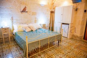 ein Schlafzimmer mit einem Bett in einer Steinmauer in der Unterkunft [Borgo Antico-Centro Storico] Casa Ventosa in Oria