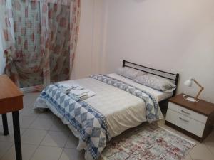 a small bedroom with a bed and a table and a lamp at sofi in Komotini