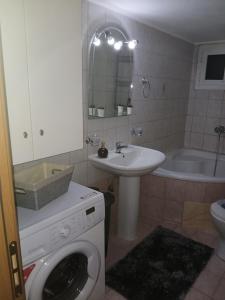 a bathroom with a washing machine and a sink at sofi in Komotini