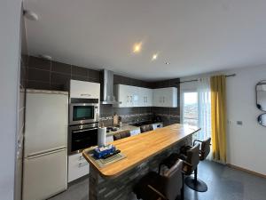 Il comprend une cuisine équipée d'un comptoir en bois et d'un réfrigérateur. dans l'établissement Une appartement entier à Brive la gaillarde, à Brive-la-Gaillarde