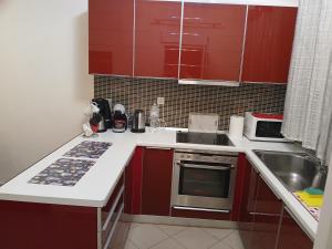 a small kitchen with red cabinets and a sink at sofi in Komotini