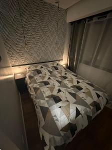 a bedroom with a black and white comforter on a bed at Djokovic Colmar in Colmar