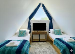 two twin beds in a room with a tv at Clifftop Chalet With Pool in Deal +11 photos