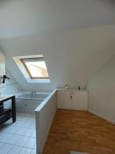 a attic room with a skylight and a bath tub at Appartement Dôme 2 suites parentales in Ostwald +9 photos