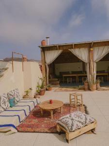 a patio with couches and a table and a tent at Dania Surf House in Mirleft