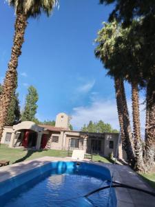 a house with a swimming pool and palm trees at La gran morada in Corralitos