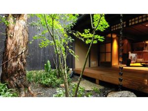 un banc en bois dans un jardin à côté d'un arbre dans l'établissement Kishoan did - Vacation STAY 81774v, à Shimmachidōri