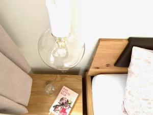 a lamp on a table next to a bed at Ferienwohnung Im Dorf Urnäsch in Urnäsch