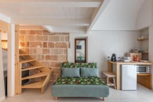 Una sala de estar con un sofá y una pared de ladrillos. en MandorleOlio Versomare, en Polignano a Mare