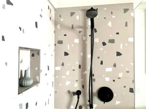 a bathroom with a shower with a wall covered in stickers at Ferienwohnung Im Dorf Urnäsch in Urnäsch