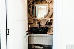 a bathroom with a sink and a mirror at Jessica luxury Apartament in Curtea de Argeş +28 photos