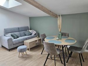 a living room with a table and a couch at Mon pinot bord de l'eau in Savigny-lès-Beaune