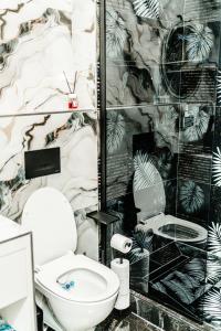 a bathroom with a toilet and a wall mural at Jessica luxury Apartament in Curtea de Argeş