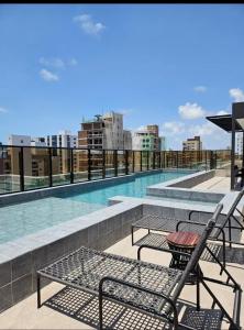 a balcony with chairs and a pool on a building at Azzure Apartmento 103 Intermares in Cabedelo