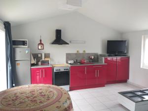 eine Küche mit roten Schränken und einem roten Kühlschrank in der Unterkunft La Mignonnette in Grues + 13 Fotos