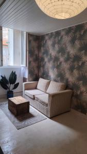 ein Wohnzimmer mit Sofa und Tisch in der Unterkunft À louer Charmant T2 en rez-de-chaussée à Châteaumeillant in Châteaumeillant