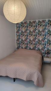 ein Schlafzimmer mit einem Bett mit Blumentapete in der Unterkunft À louer Charmant T2 en rez-de-chaussée à Châteaumeillant in Châteaumeillant