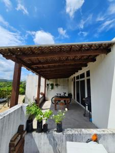 eine Terrasse mit einer hölzernen Pergola auf einem Haus in der Unterkunft Habitación con pérgola independiente in Flores