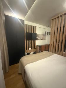 a bedroom with a white bed and a desk at N-LUX 66 MILMARI kopaonik in Kopaonik
