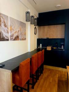 a kitchen with a black counter and orange chairs at N-LUX 66 MILMARI kopaonik in Kopaonik