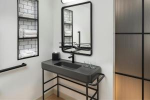 ein Badezimmer mit Waschbecken und Spiegel in der Unterkunft Moxy Fayetteville in Fayetteville + 49 Fotos